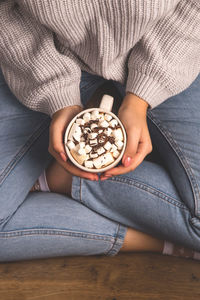 High angle view of woman sitting with cocoa cup