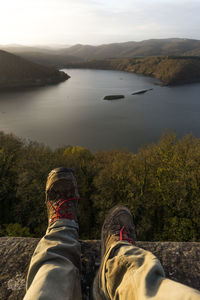Low section of man standing by lake