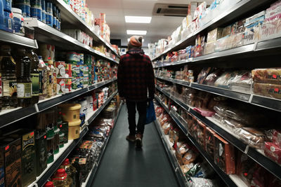 Rear view of man walking in supermarket