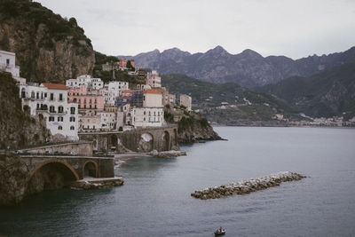 Scenic view of residential buildings by sea against sky