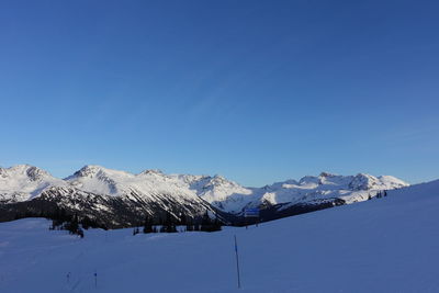 Scenic view of snowcapped mountains against clear blue sky