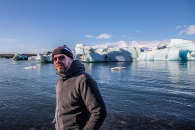 Portrait of man standing against sea during winter