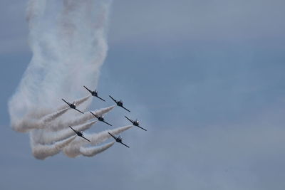 Low angle view of airplane against cloudy sky