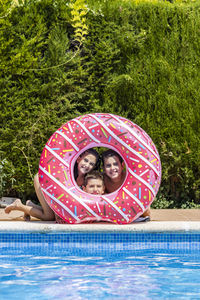 Three kids posing on a hole of a rubber ring