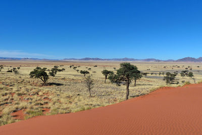 Scenic view of desert against clear blue sky