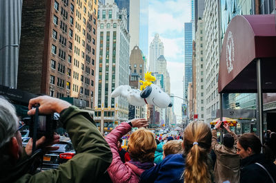 People on street against buildings in city