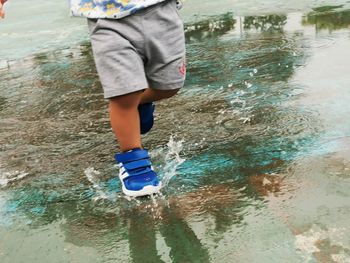 Low section of boy standing in water