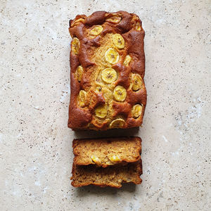 High angle view of healthy banana bread loaf sliced on stone table