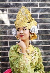 Portrait of woman standing against yellow wall