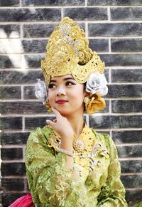 Portrait of woman standing against yellow wall