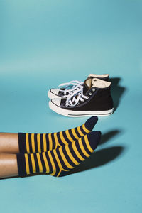 Low section of person wearing striped socks on blue background