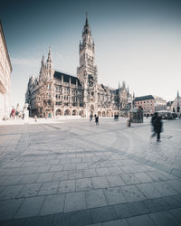 People on street by buildings in city