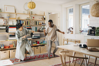 Cheerful couple dancing in living room at home