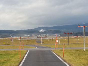 Empty road against cloudy sky