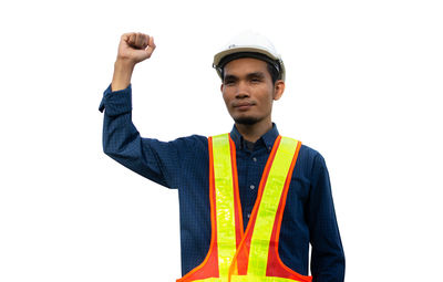 Portrait of young man standing against white background