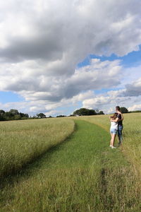 Rear view of women on field against sky