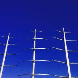 Low angle view of windmill against clear blue sky