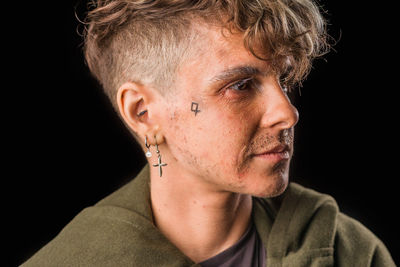 Close-up portrait of man against black background