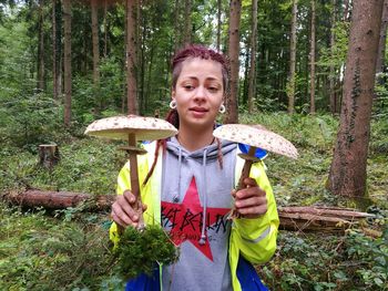 Portrait of smiling woman standing in forest