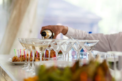 Cropped hand of man pouring wine in glass