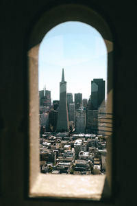 Cityscape against sky seen through window