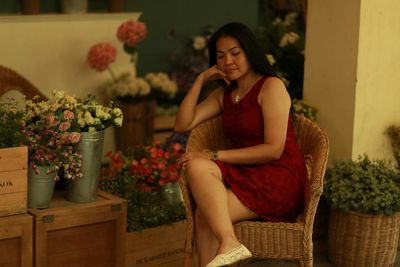 Mature woman with eyes closed sitting on armchair at flower shop