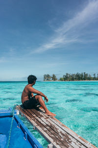 Rear view of man  sitting on the boat