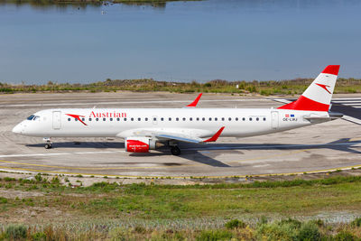 Airplane on airport runway against sky