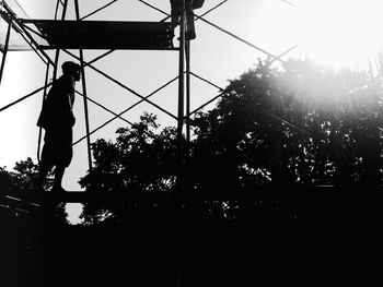 Silhouette woman standing by plants against sky