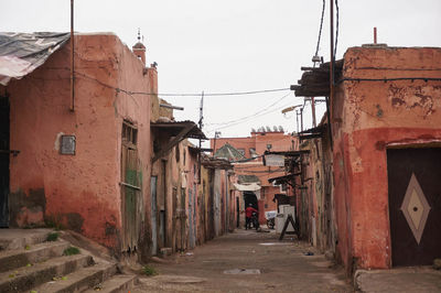 Alley amidst buildings in town against sky