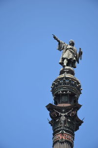 Low angle view of statue against blue sky