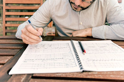 Midsection of man sitting on paper
