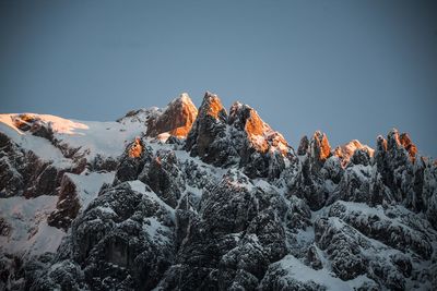 Low angle view of snowcapped mountain against clear sky