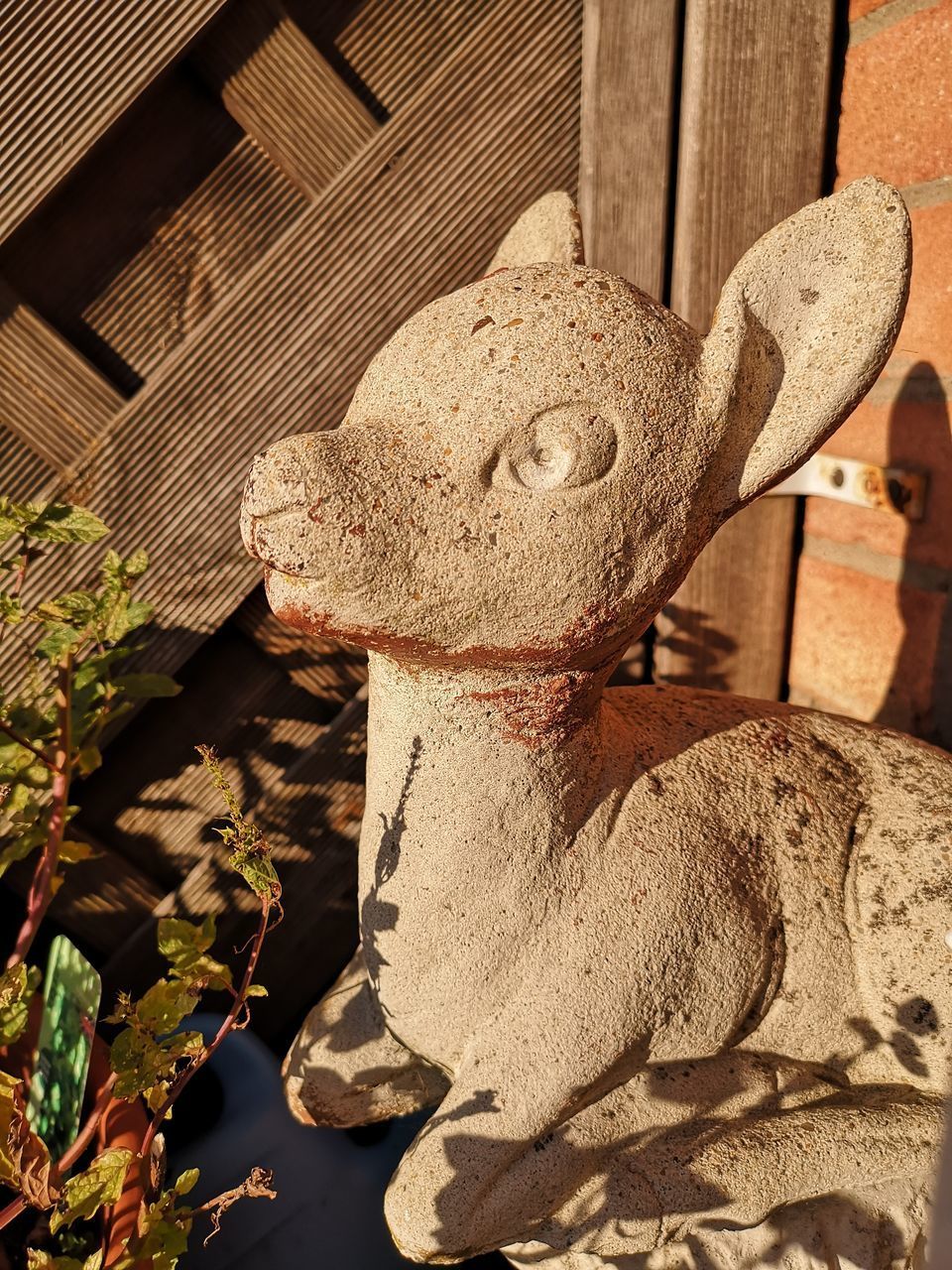 CLOSE-UP OF STATUE AGAINST OLD BUILDING