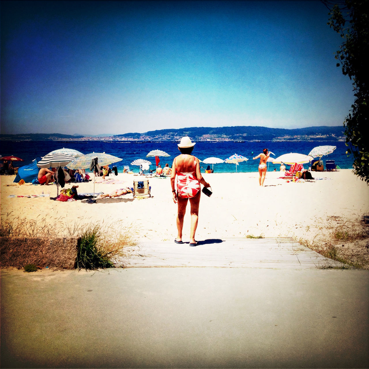 clear sky, beach, sand, copy space, sea, leisure activity, full length, lifestyles, shore, water, rear view, person, blue, horizon over water, childhood, casual clothing, vacations, sunlight, summer