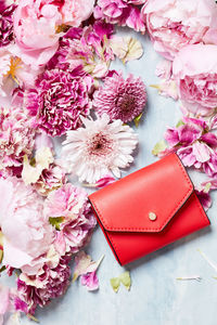 Still life of red clutch purse and flower pedals