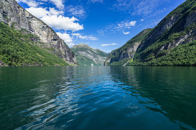 Scenic view of lake by mountains against sky