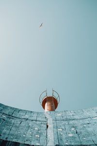 Low angle view of bird flying against clear sky