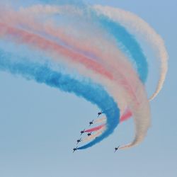 Low angle view of airshow against sky