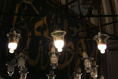 Low angle view of illuminated light bulbs hanging from ceiling