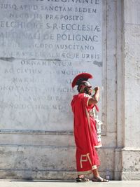 Side view of man in costume standing against wall