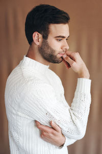 Side view of young man smoking cigarette