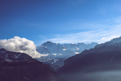 Scenic view of snowcapped mountains against blue sky