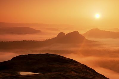 Dreamy misty landscape. majestic mountain cut the lighting mist. colorful fog and rocky hills