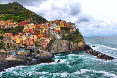 Scenic view of sea by buildings against sky