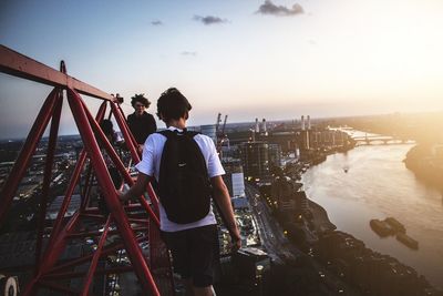 Rear view of people standing by sea against clear sky