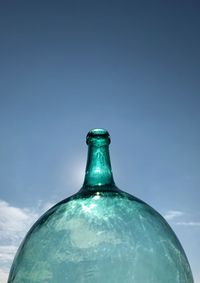 Close-up of glass bottle against blue background