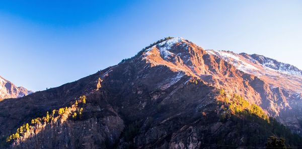 Low angle view of mountain against clear blue sky