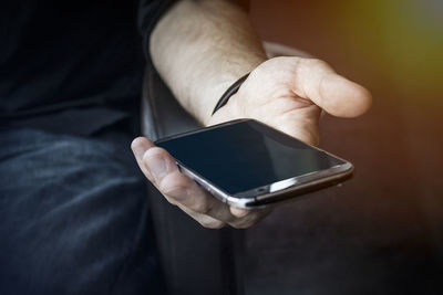 Midsection of man using mobile phone