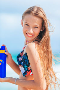 Portrait of smiling young woman with eyes closed against sky